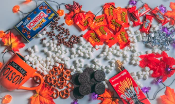 Halloween candy and chocolate scattered among fall leaves