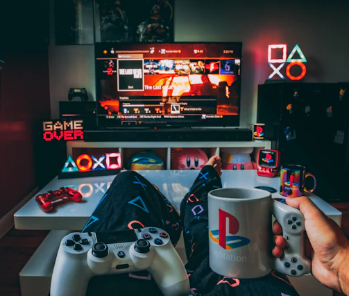 a person holding a cup and a game controller in front of a television