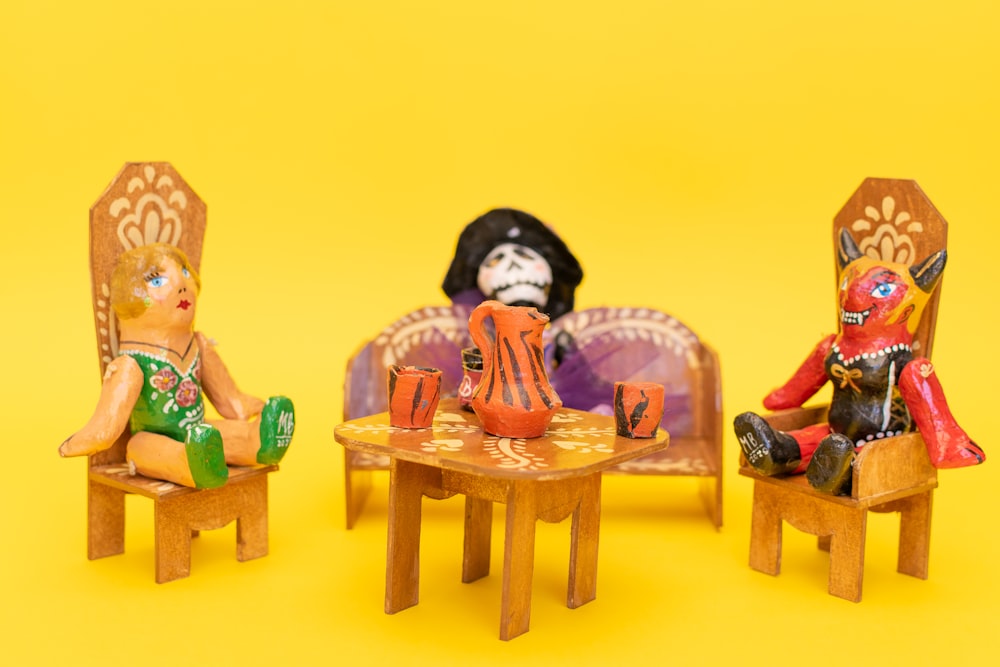 a group of dolls sitting on chairs