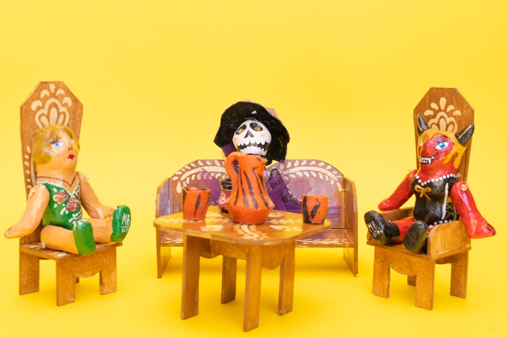 a group of dolls sitting on chairs