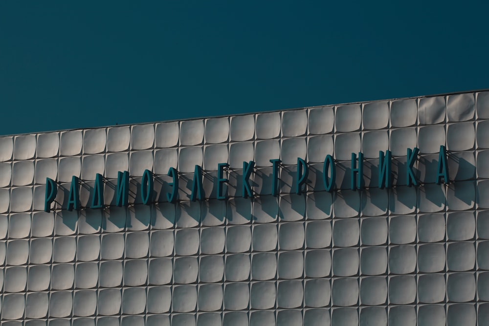 a white fence with blue and green letters on it