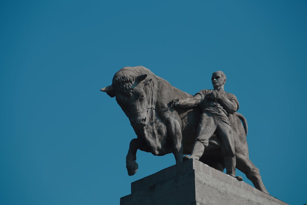 a statue of a person riding a bull