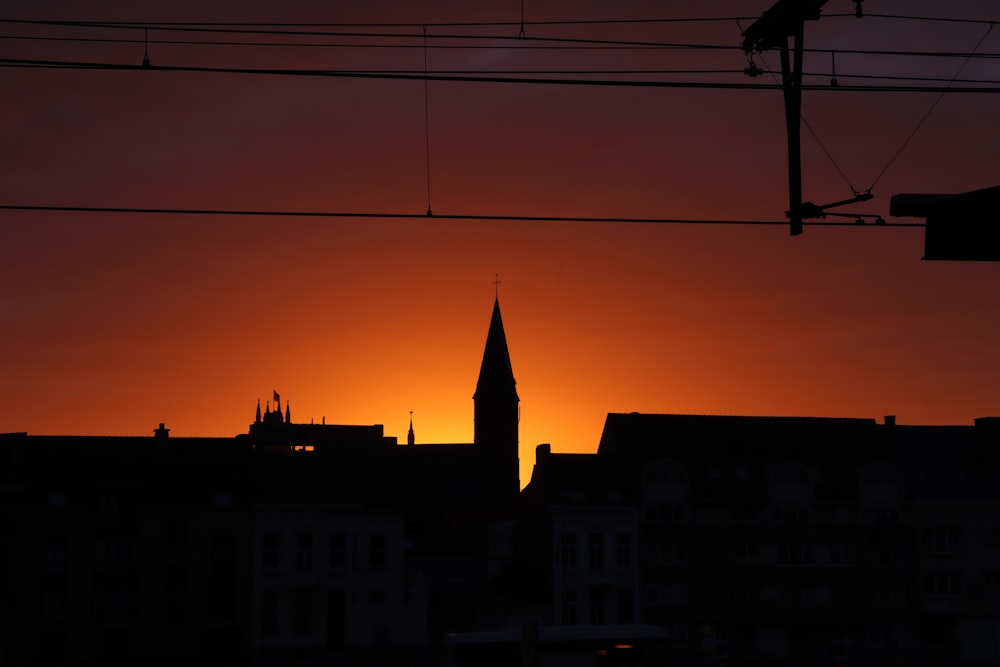 a silhouette of a building and a tower at sunset