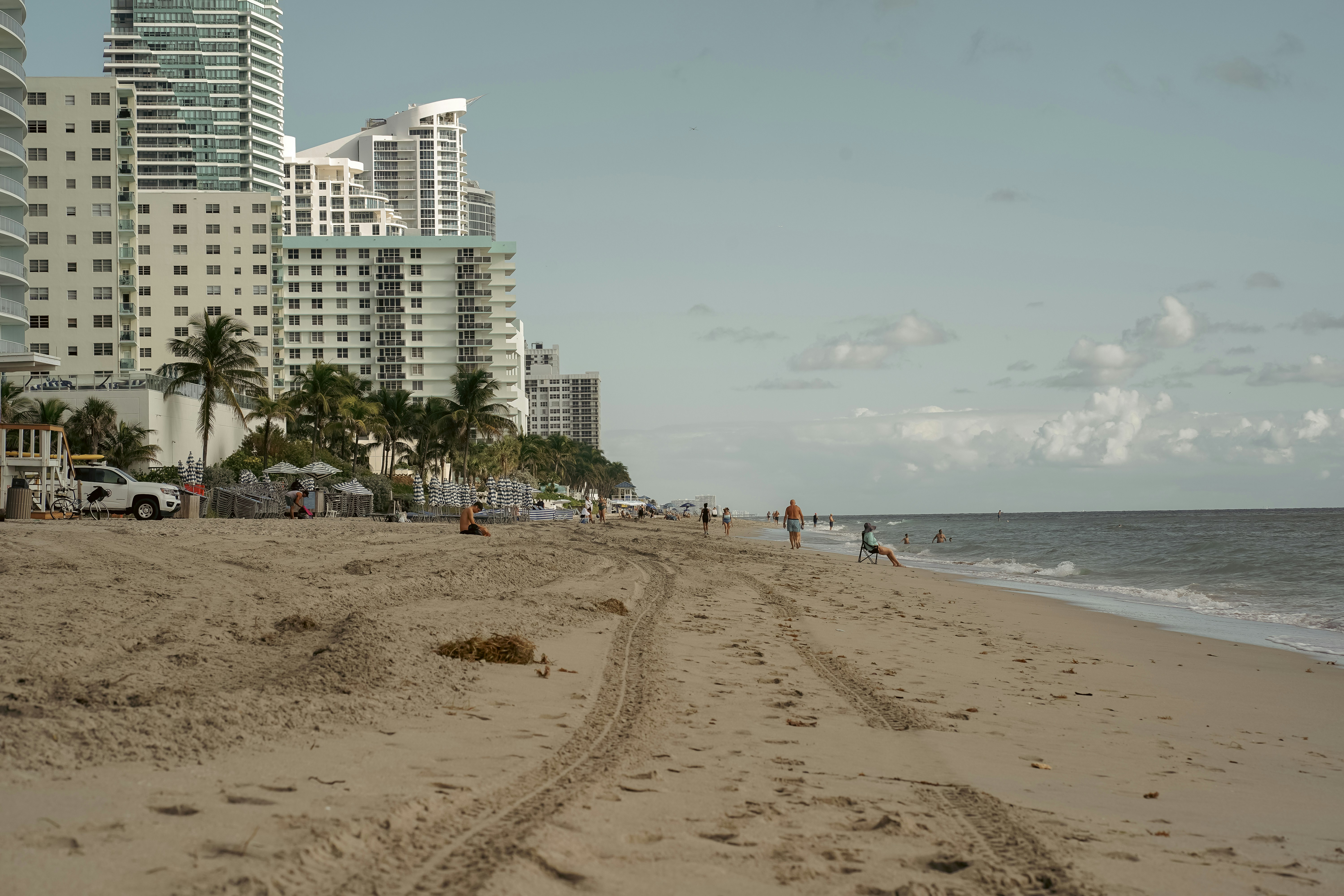 a beach with people and buildings in the background
