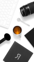 a cup of coffee and a cell phone on a table