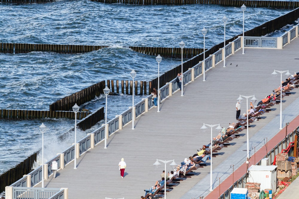 a group of people sitting on a deck next to a body of water