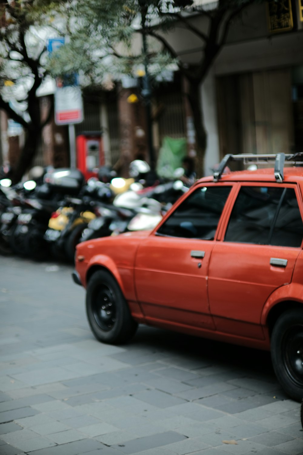 a red car parked on the side of a street