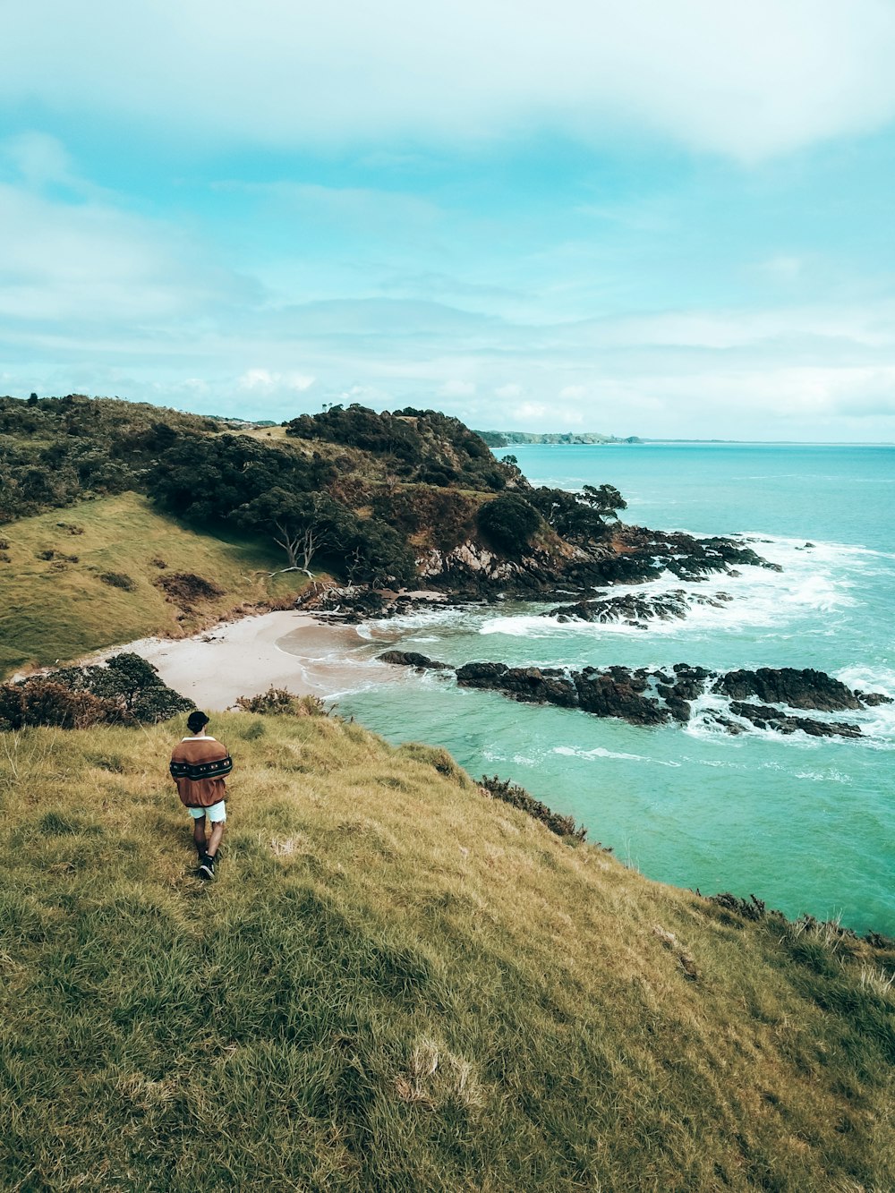 a person walking on a path near a beach