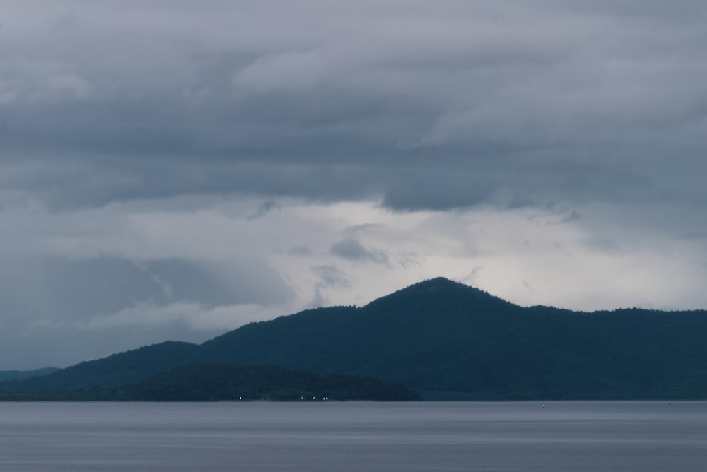 a body of water with a mountain in the background