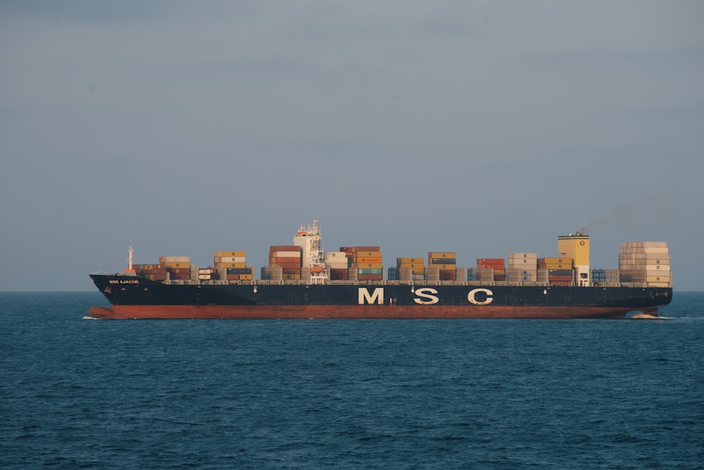 a large ship with a large cargo ship on it with Staten Island Ferry in the background