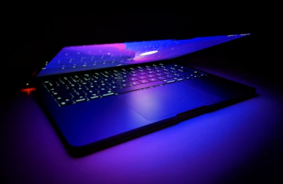 Close-up of a luxury tech device glowing with electric violet and blue light accents.