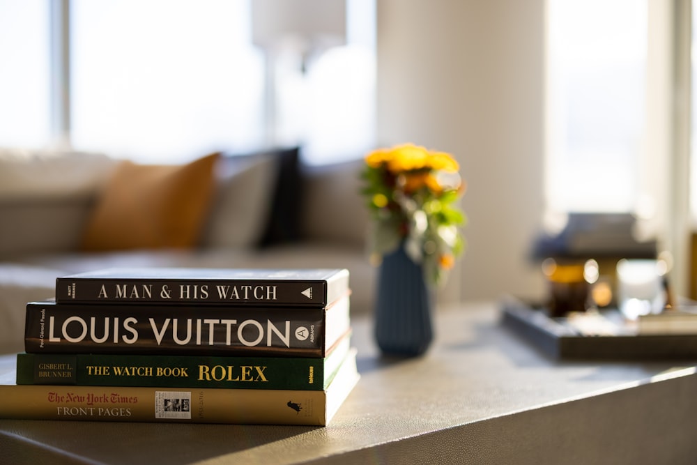 a vase of yellow flowers sits on top of a stack of books