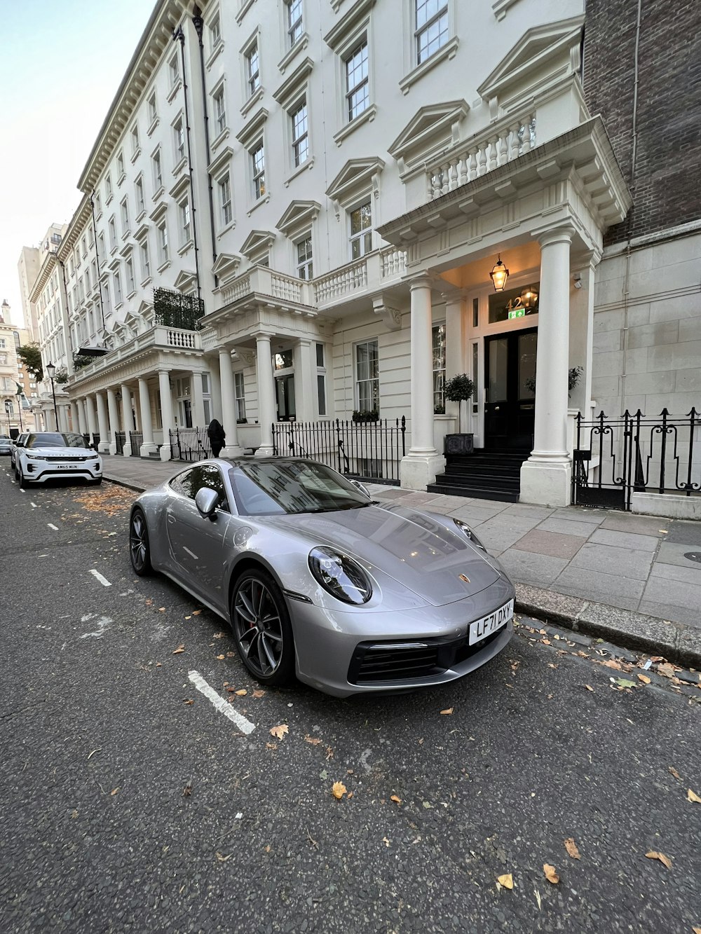 a silver sports car parked on the side of a street