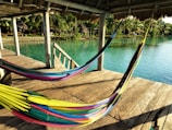 Guests enjoying a peaceful moment on a hammock overlooking Holbox’s sparkling waters.