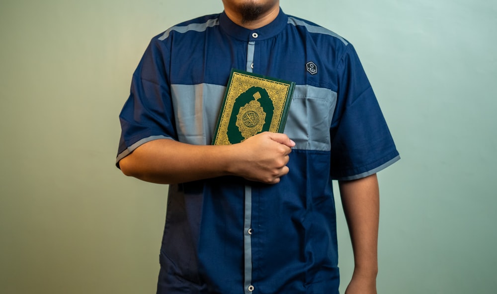 a man wearing a blue shirt with a gold emblem on it