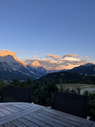 A breathtaking mountain peak event setup with elegant decorations and guests enjoying a sunset.