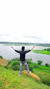 A person standing on a hilltop, arms outstretched, breathing deeply in the open air.