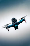 Close-up of a drone in flight against a bright blue sky.
