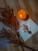 A warmly lit scene showing someone thoughtfully writing a letter at a rustic wooden desk.