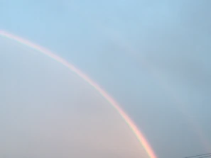 Illustration of a gentle rainbow arch with pastel colors and small shining stars.