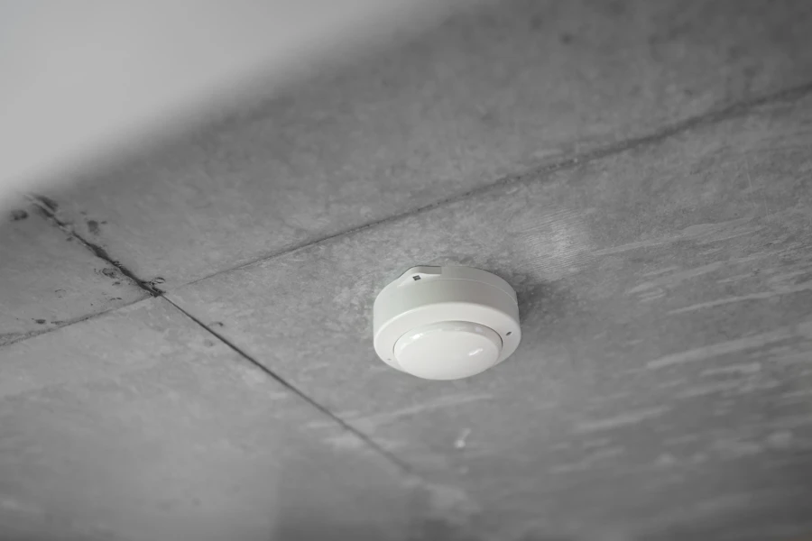 Ceiling-mounted smoke detector in a quiet residential hallway