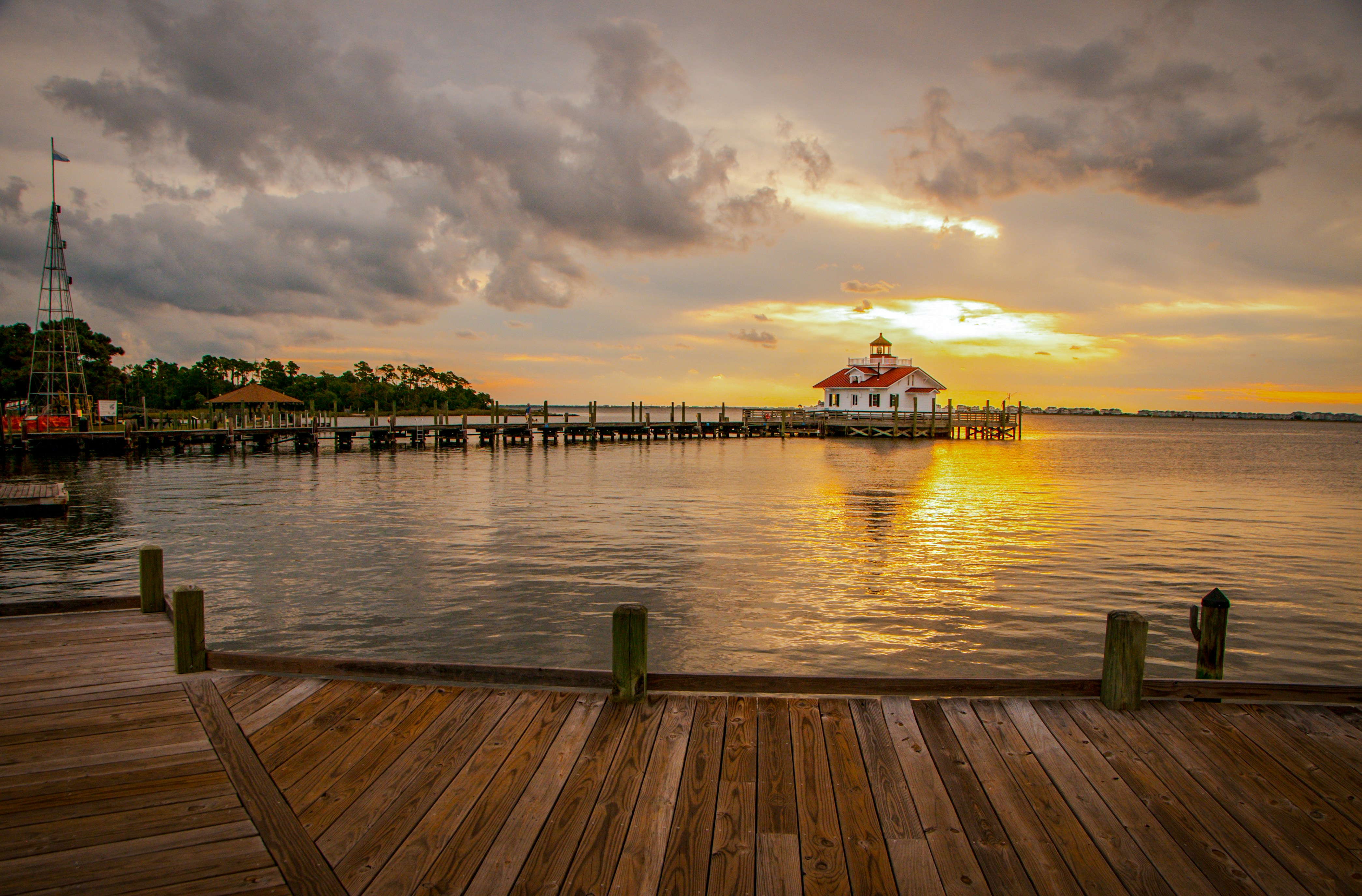 a dock with a building on it and a tower in the background