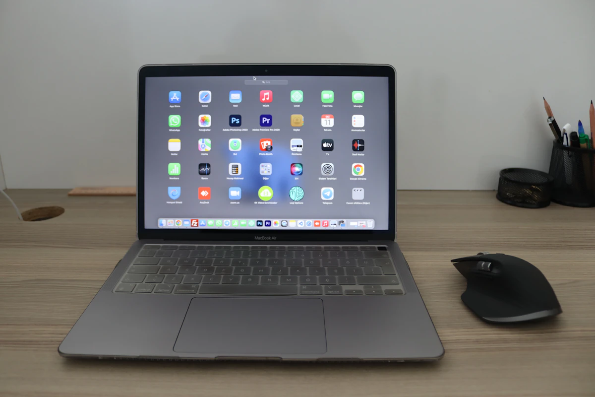 Silver MacBook Air laptop open on a white desk showing macOS interface