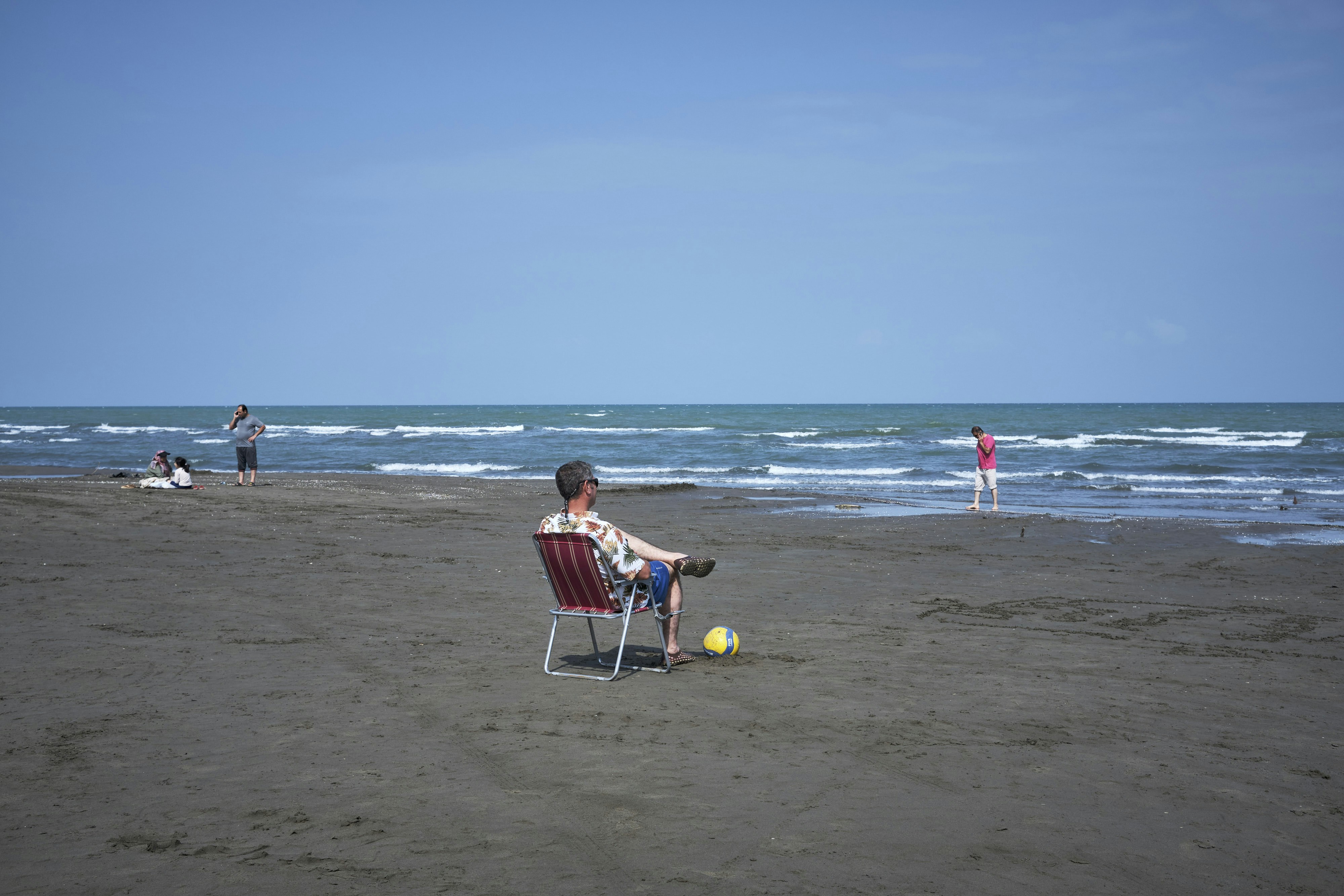 a man sitting in a chair on a beach
