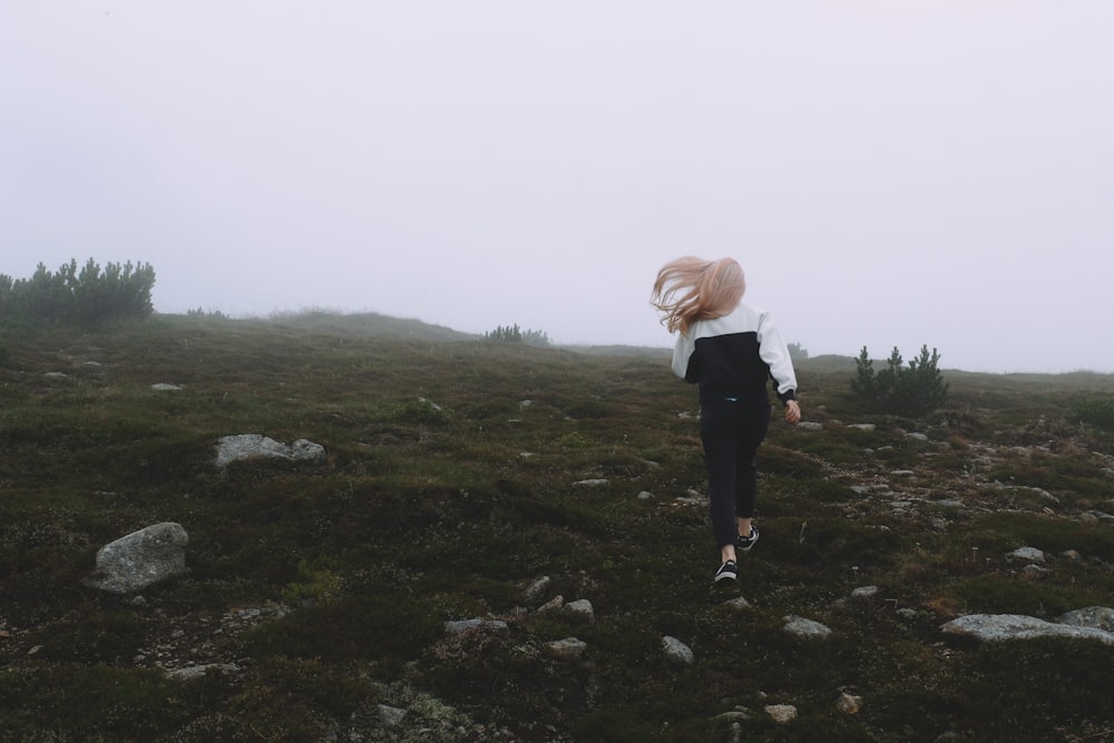 a person walking on a grassy hill