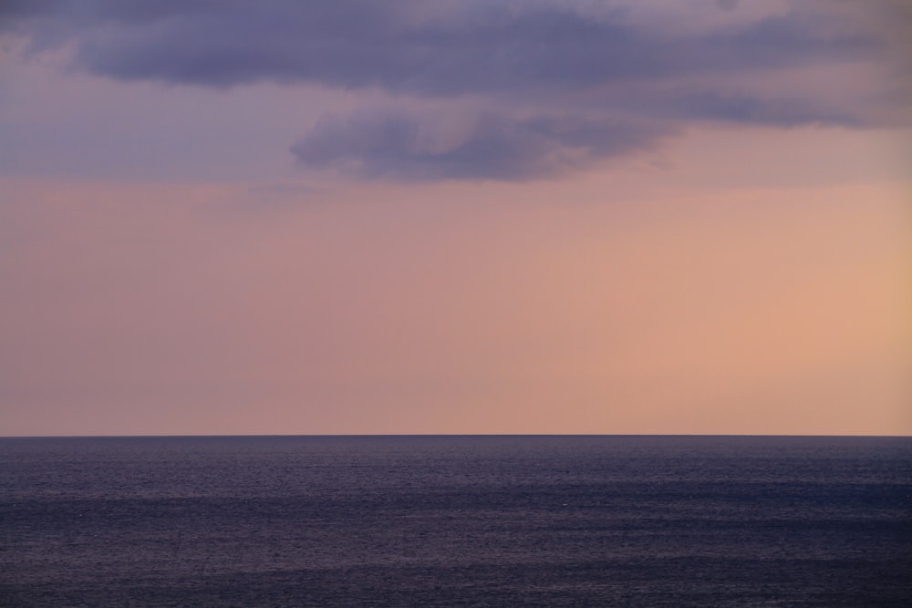 a body of water with a cloudy sky above it