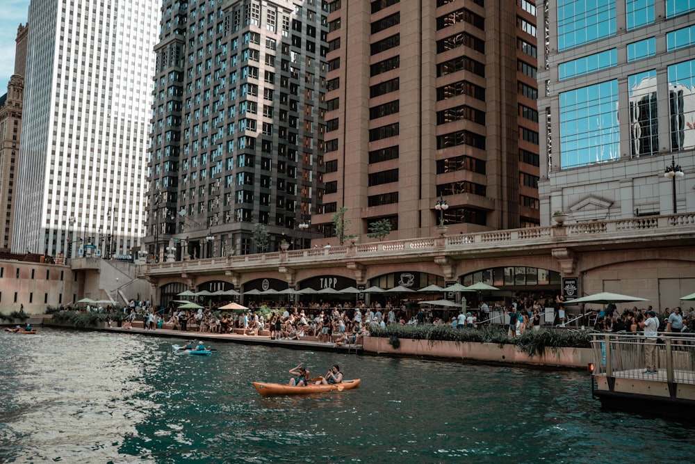 Un groupe de personnes en kayak sur une rivière entre des bâtiments