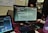 Developer reviewing code on a laptop in a modern workspace with multiple monitors.