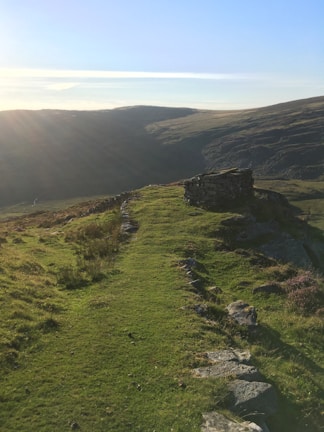 A serene landscape with a winding path through soft hills.
