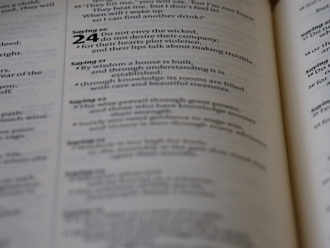 A close-up view of an open book showing text, consisting of paragraphs and numerical headings. The text includes a bolded number 24 and seems to be laid out in a structured format.