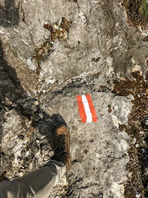 Close-up of rugged hiking boots on a rocky mountain trail