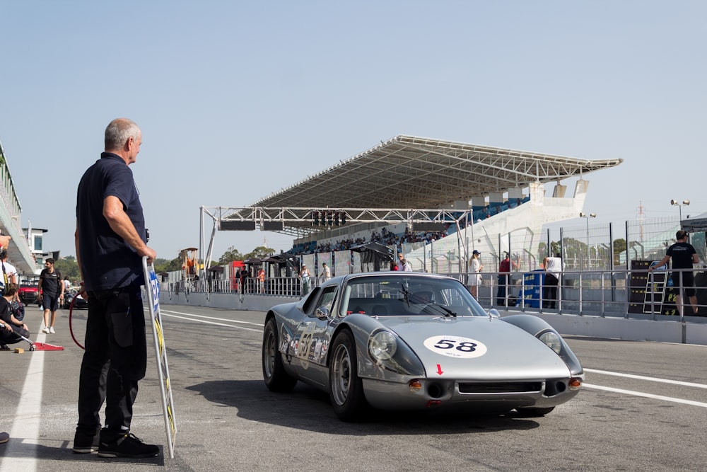 a man standing next to a sports car