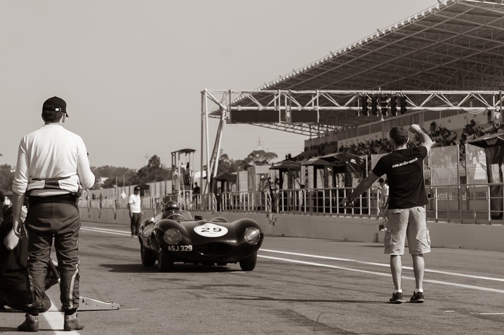 a man pointing at a race car