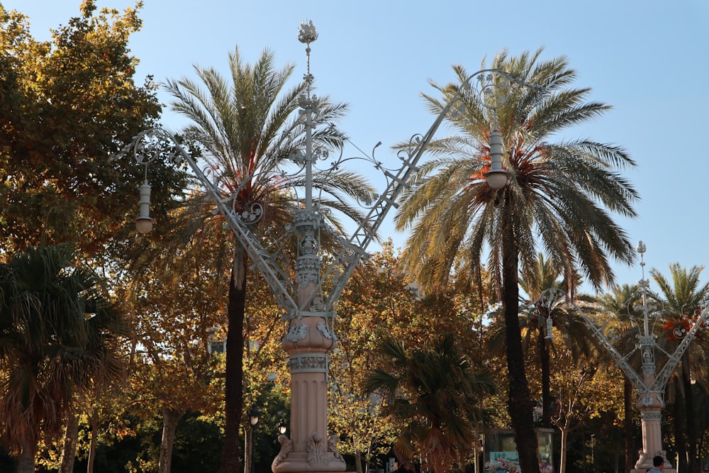 a tall tower with a cross on top surrounded by trees