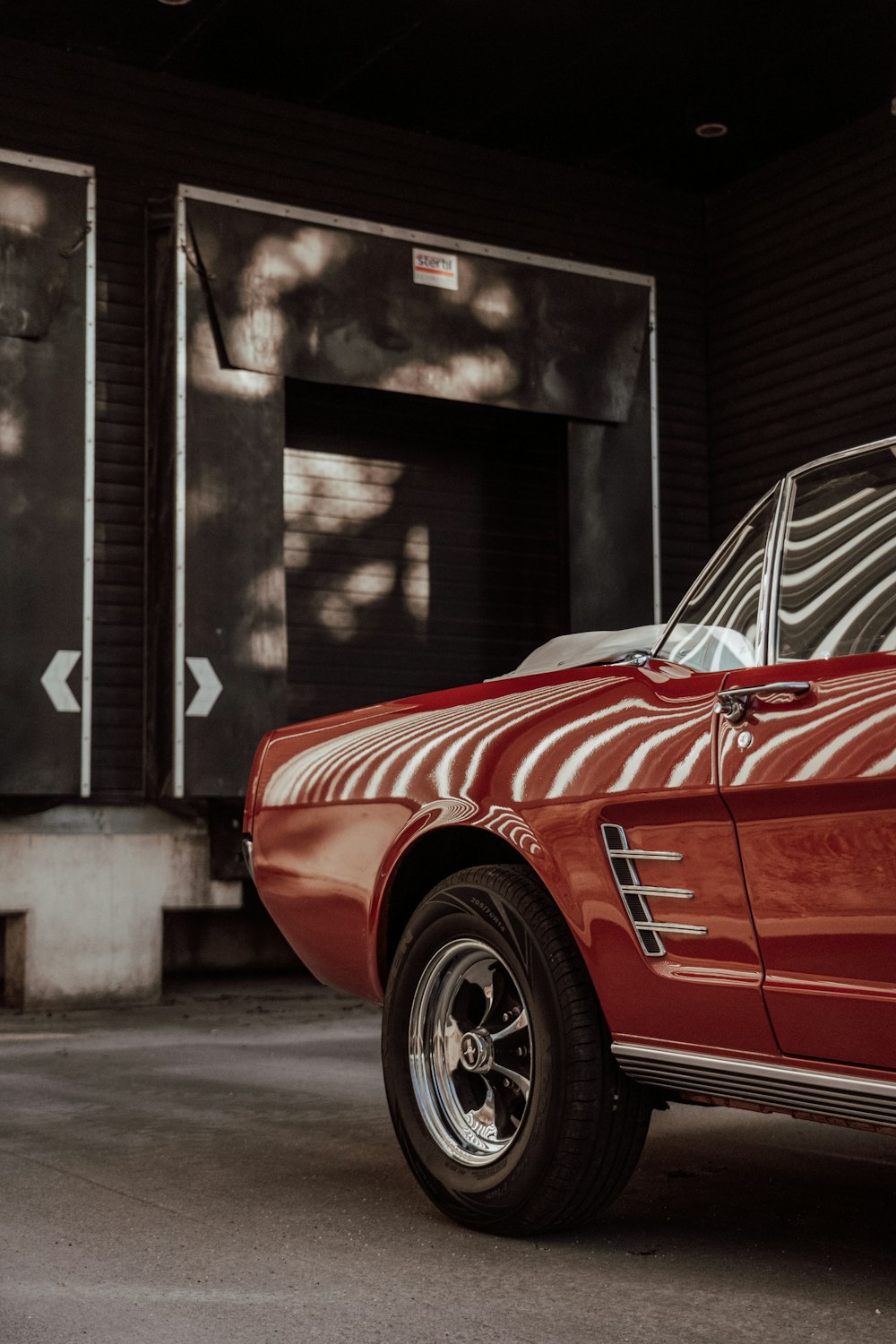 a red car parked in front of a garage