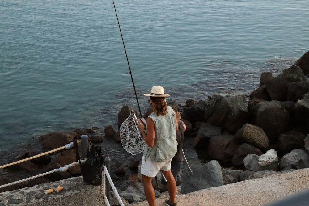 a person fishing on a rocky shore
