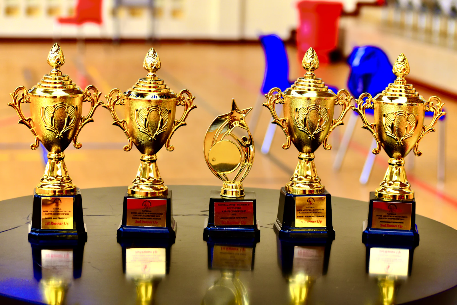 Gold-coloured trophy cups lined up on a shelf