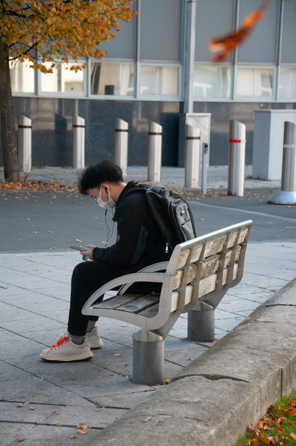 a man sitting on a bench looking at his phone