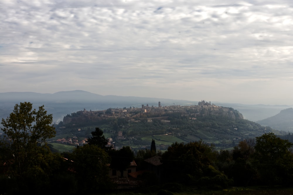 a city with trees and mountains in the background