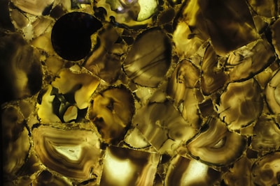 An abstract Andean-modern pattern etched in obsidian stone, illuminated softly to reveal intricate details.