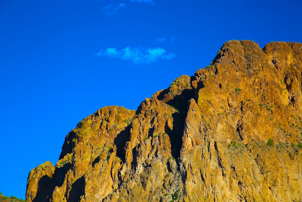 Una montaña rocosa con un cielo azul