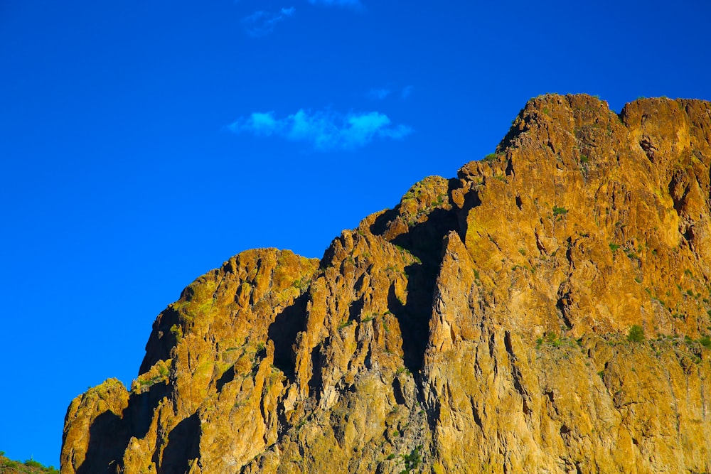 a rocky mountain with a blue sky