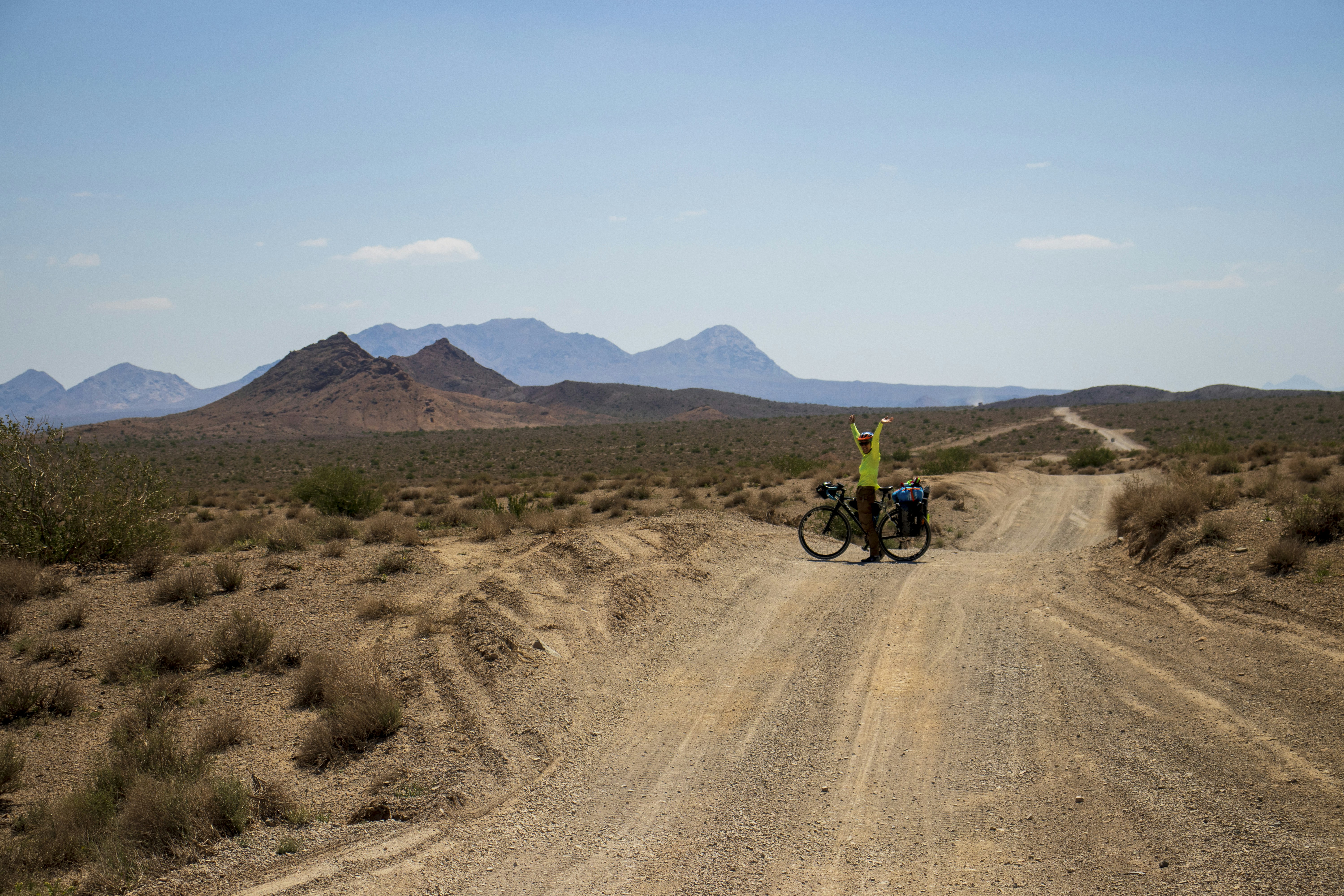 a person on a bike on a dirt road in the desert