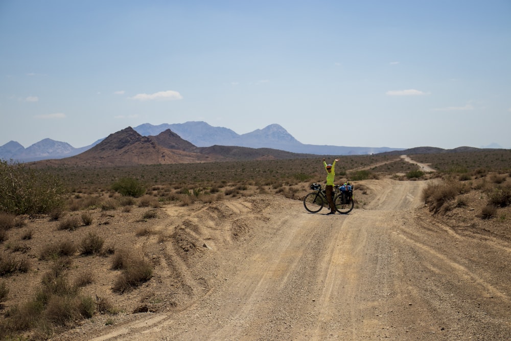 a person on a bike on a dirt road in the desert
