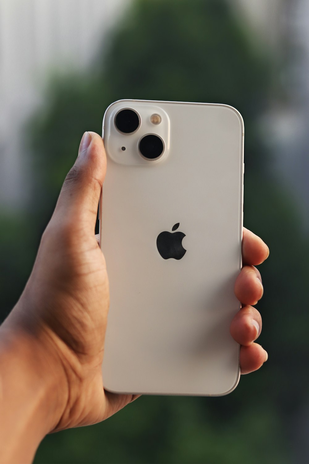 a hand holding a white cell phone