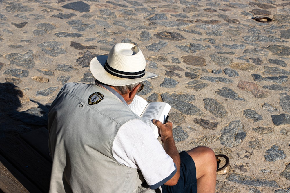 a man reading a book on the beach